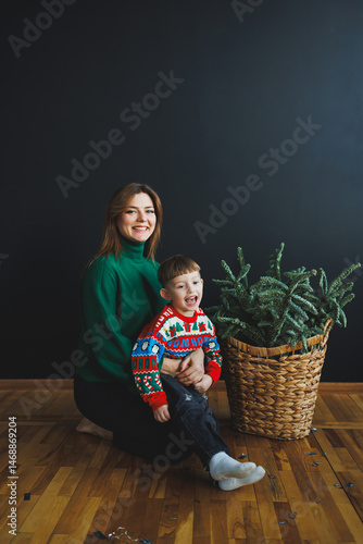 Obraz na płótnie Mom spends time with her son on New Year's Eve at home. Holiday games of mom with son at home. Cheerful childhood. w salonie