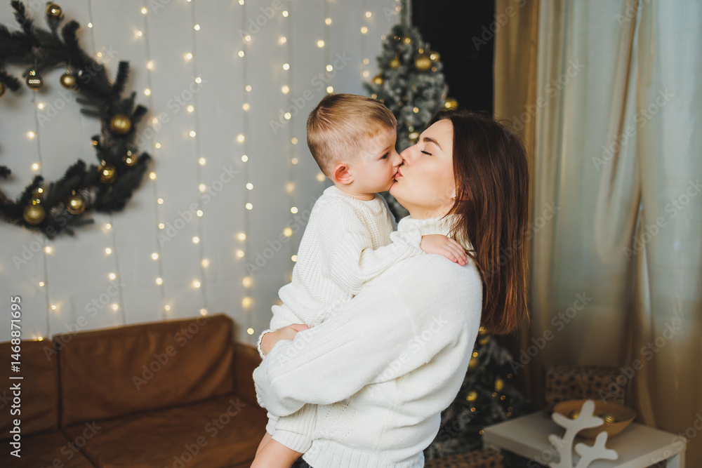 Mom spends time with her son on New Year's Eve at home. Holiday games of mom with son at home. Cheerful childhood.