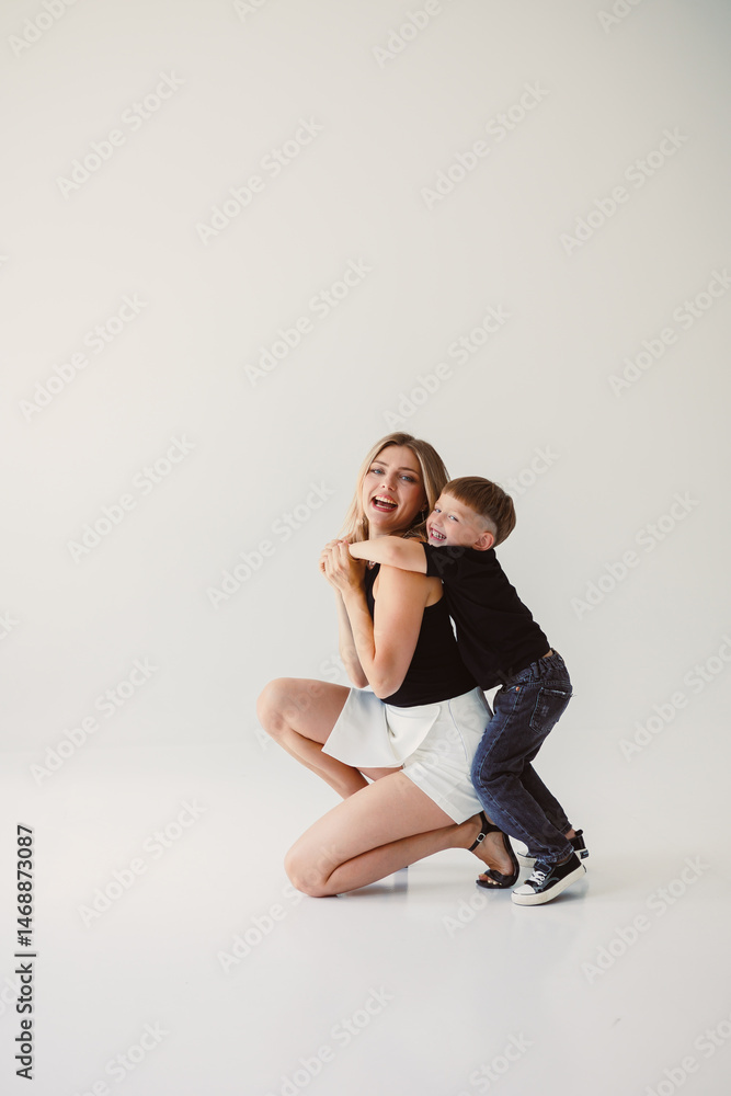 Mom and 4 year old son smiling and hugging on a white background. Warm relationship between mom and son. Concept of family relationships between mom and son.