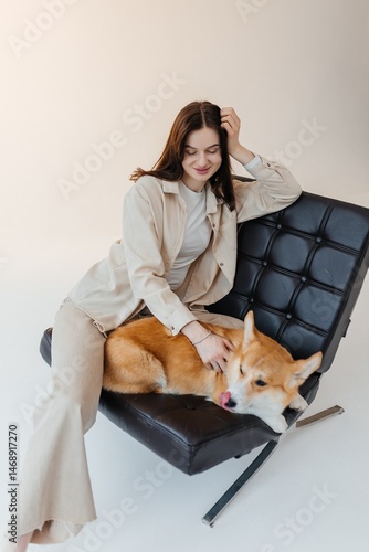 Obraz na płótnie Young woman playing with her corgi dog. Healthy lifestyle and living in an apartment with a pet. Pets concept. w salonie