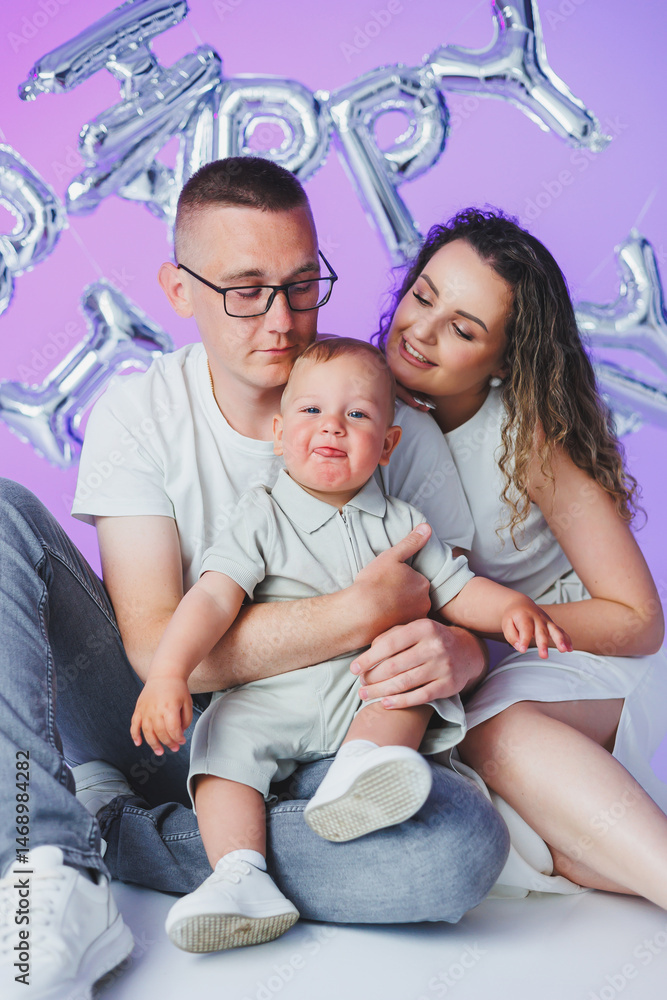 Happy parents hugging their one year old son. Mom dad and their toddler son smiling and hugging. Cheerful family relationships. Concept of happy parents with child.