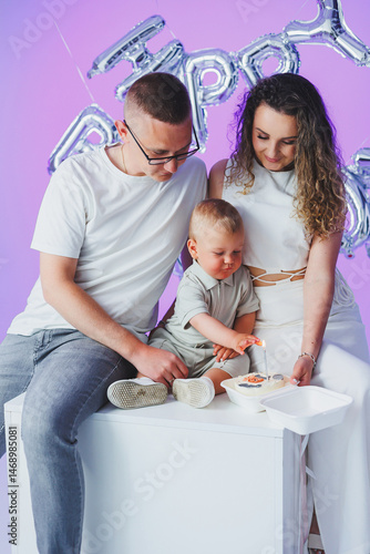 Obraz na płótnie Happy parents hugging their one year old son. Mom dad and their toddler son smiling and hugging. Cheerful family relationships. Concept of happy parents with child. w salonie