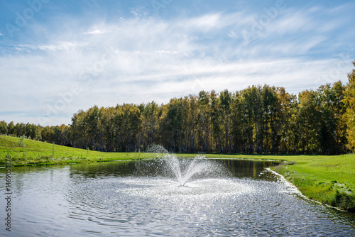 Wallpaper Mural A serene and tranquil pond featuring a beautiful fountain amidst a lush green landscape Torontodigital.ca