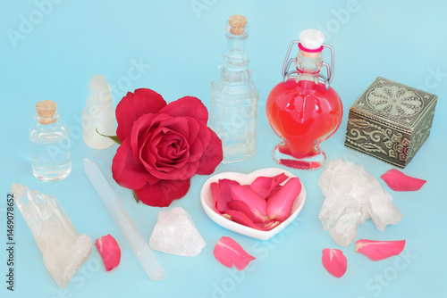 Rose flower love potion witchcraft concoction for unrequited love or Valentines day. Preparation with rose and quartz crystals, wand and heart shape bottle for spell.