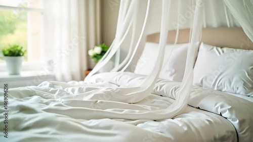 Cozy bed with white linens and sheer canopy in soft light  