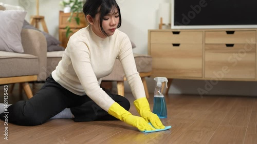 Cleanliness, asian young woman work chore cleaning on floor at home, hand wearing glove using wiping cloth remove dust with spray bottle. Household hygiene clean up, equipment tool for cleaning