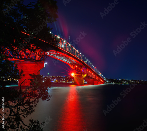Obraz na płótnie Auckland Harbour Bridge glowing in red lights. Auckland. New Zealand. w salonie