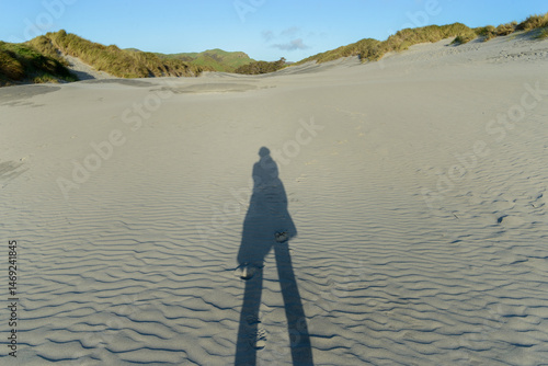 Obraz na płótnie Long shadow of a woman on sand dunes. Wharariki Beach. Golden Bay. South Island. w salonie