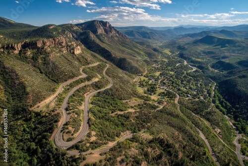 Obraz na płótnie Scenic Switchback Road Winds Through Lush Mountains in Summer Landscape Under Blue Skies Generative AI w salonie