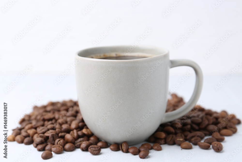 Aromatic coffee in cup and beans on white background, closeup Aromatic coffee in cup and beans on white background, closeup