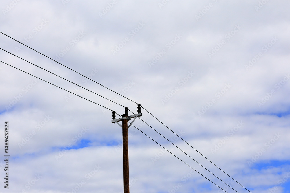 Wooden pole, electricity net with wires. Cloudy day.