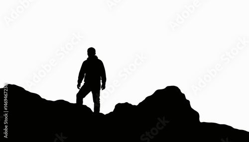 Silhouette of a mountaineer standing on rocky terrain, adventurous spirit