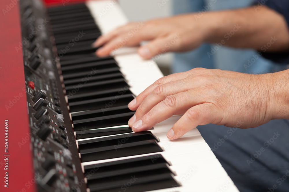 Obraz premium Music creation process in a cozy space with hands playing an electronic keyboard instrument