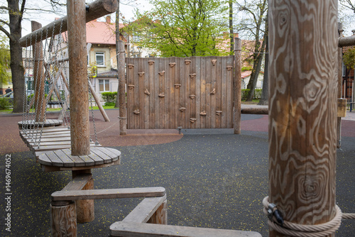 Wooden modern ecological safety children outdoor playground equipment in public park in city. kids rest and childhood