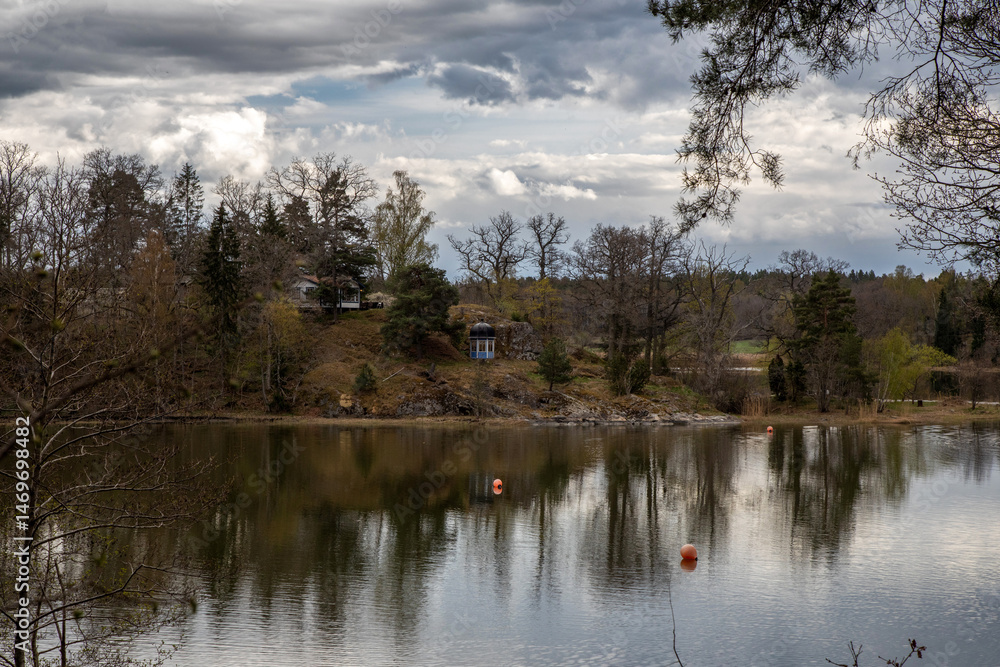 Obraz premium Lake shore under cloudy sky on spring evening