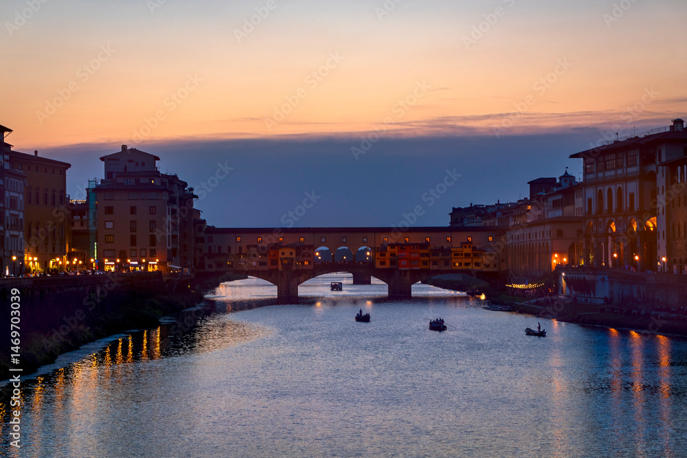 Famous Ponte Vecchio bridge over the Arno river at Florence by night, Tuscany, Italy