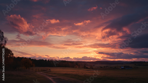 A fiery sunset paints the sky with vibrant hues over a tranquil landscape
