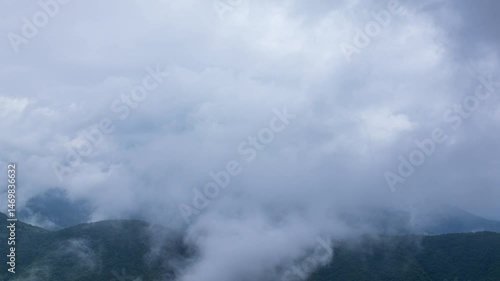 タイムラプス　雨の日の山頂を、覆いかぶさりながら流れていく雨雲