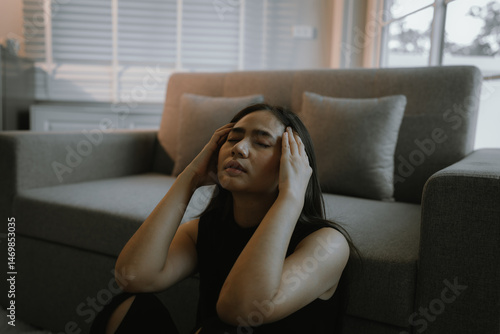 Foto A distressed young adult woman sits alone indoors, experiencing sadness, anxiety, and emotional pain, overwhelmed by grief and stress