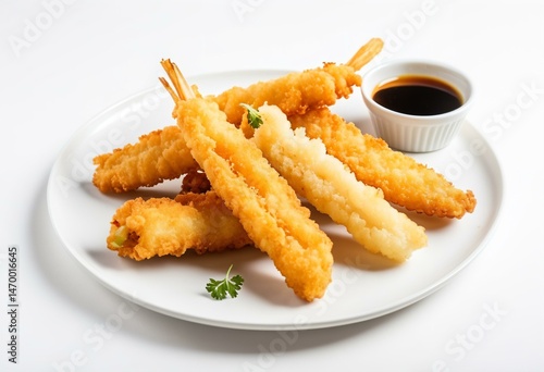A white plate topped with fried shrimp next to a bowl of dipping sauce.