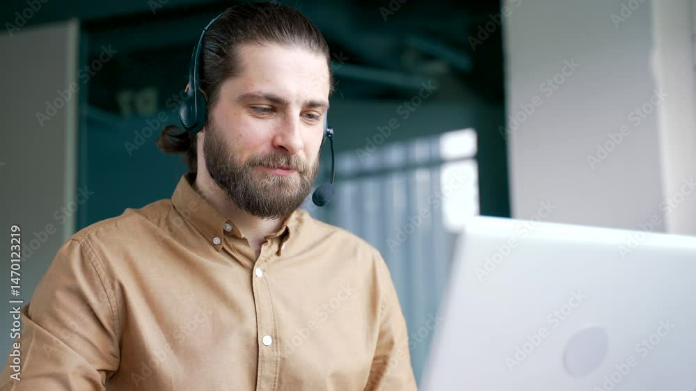 Corporate operator in headset working in customer support service on helpline telesale talking using laptop in business office. Agent of call center advises the client by answering questions. Close up