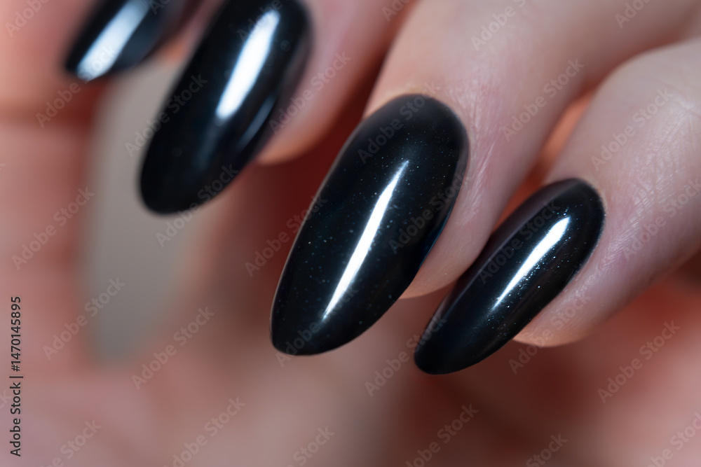 A macro shot highlighting the oval shape of the nails, coated in deep black glossy polish — a sophisticated and stylish choice for a striking look. A macro shot highlighting the oval shape of the nails, coated in deep black glossy polish — a sophisticated and stylish choice for a striking look.