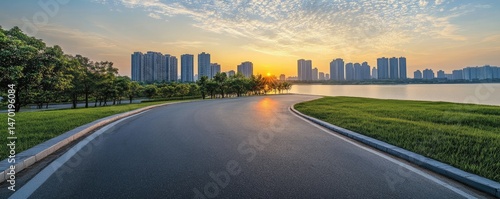 Sunset cityscape view from a curving road by a lake