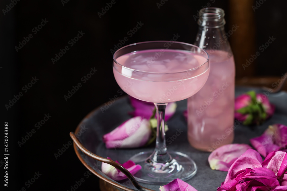 Summer refreshment drinks. Light pink rose cocktail, with rose wine on dark background. With rose flowers. Copy space