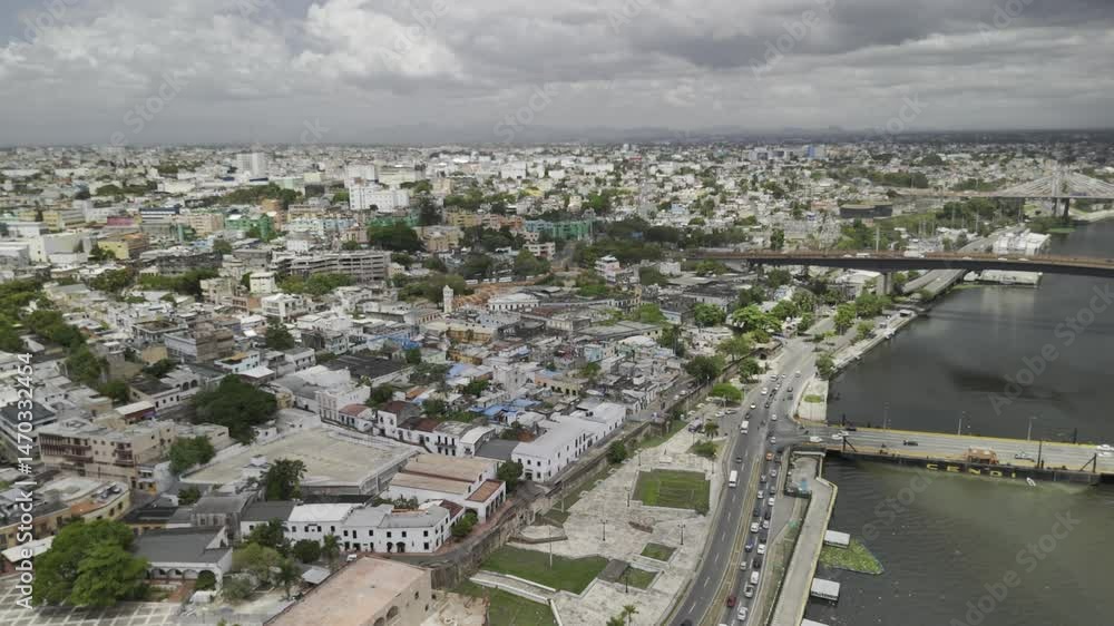 Drone flies backwards, south along the Ozama River on cloudy day in Santo Domingo, Dominican Republic Drone flies backwards, south along the Ozama River on cloudy day in Santo Domingo, Dominican Republic