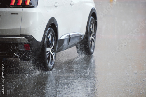White car driving on wet road in heavy rain: dynamic motion and urban transportation scene