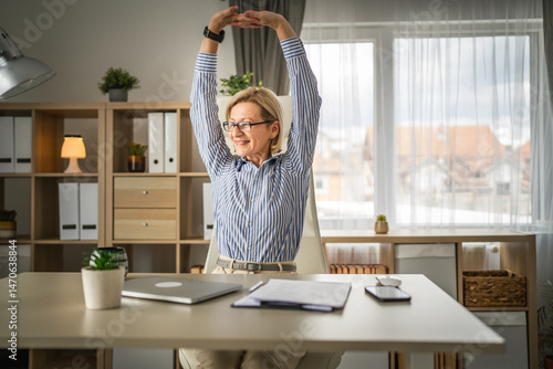 Mature woman stretches at office happy and relax