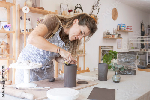Ceramist finishing the last details of her ceramic piece.