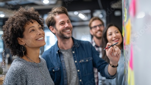 Happy diverse business team brainstorming ideas together on whiteboard men work group women notes