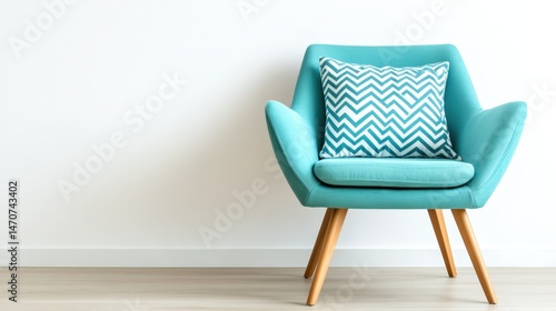 Modern turquoise armchair with decorative pillow in minimalist interior setting