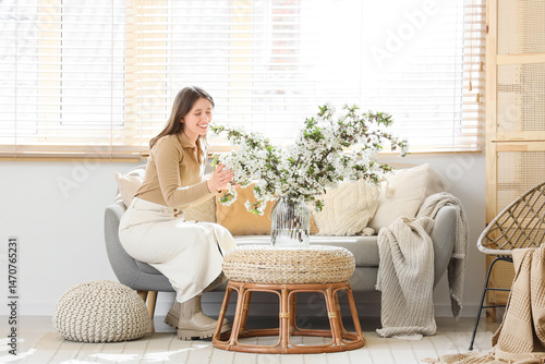 Happy young woman arranging...
