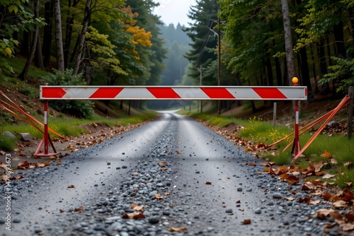 Barrier on the road: A stark red-and-white barrier blocks a rural road, highlighting a message of caution, and adding a note of intrigue with the road leading off into the distance. 