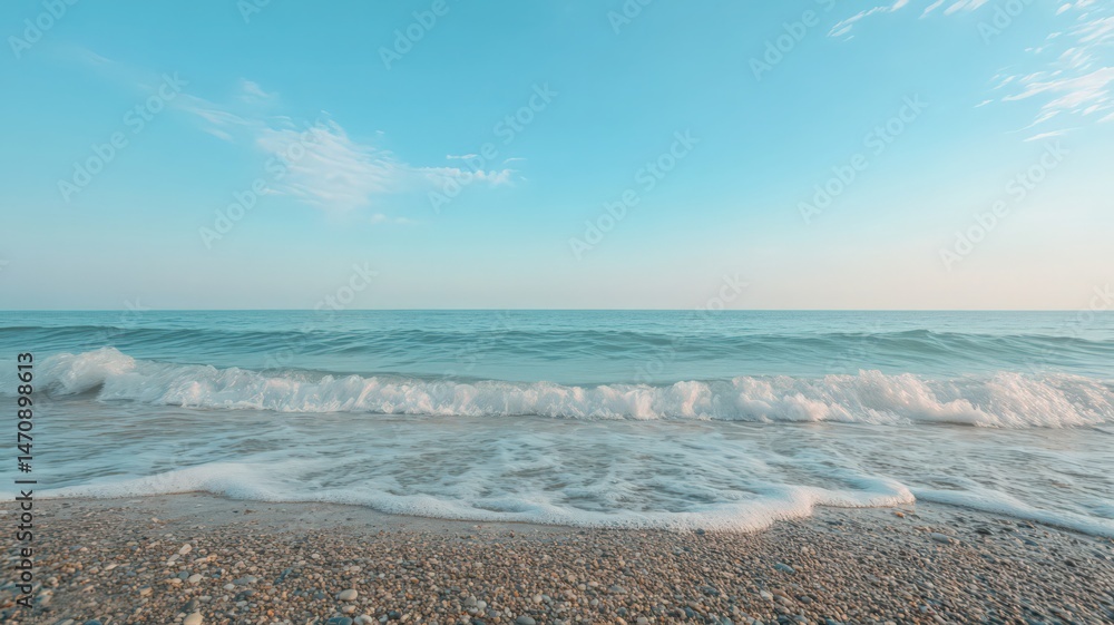 Pebbled Beach with Gentle Ocean Waves under a Serene Light Blue Sky on a Sunny Day with Clear Azure Water and Faint Clouds Pebbled Beach with Gentle Ocean Waves under a Serene Light Blue Sky on a Sunny Day with Clear Azure Water and Faint Clouds