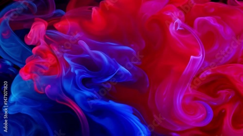 Vibrant red and blue ink clouds billow and mingle against a black background. The colorful smoke-like substances expand as the colors mix and swirl in mesmerizing motion.