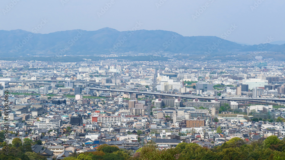 Fototapeta premium Kyoto, Japan – April 15, 2024: Panoramic view of Kyoto city and surrounding mountains from the summit of Mount Inari, along the path of Fushimi Inari Taisha, one of Japan’s most iconic landmarks.