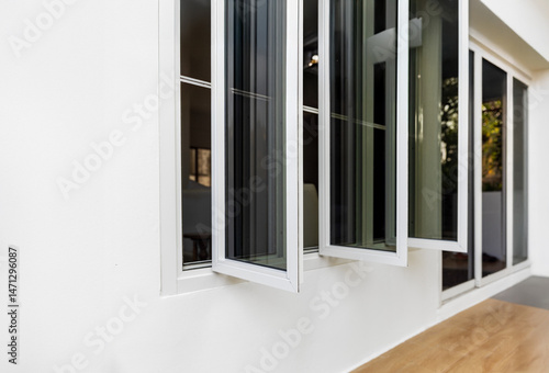 Three panel aluminium casement window stay on white wall.