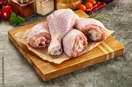 Obraz na płótnie Raw uncooked chicken drumsticks over board