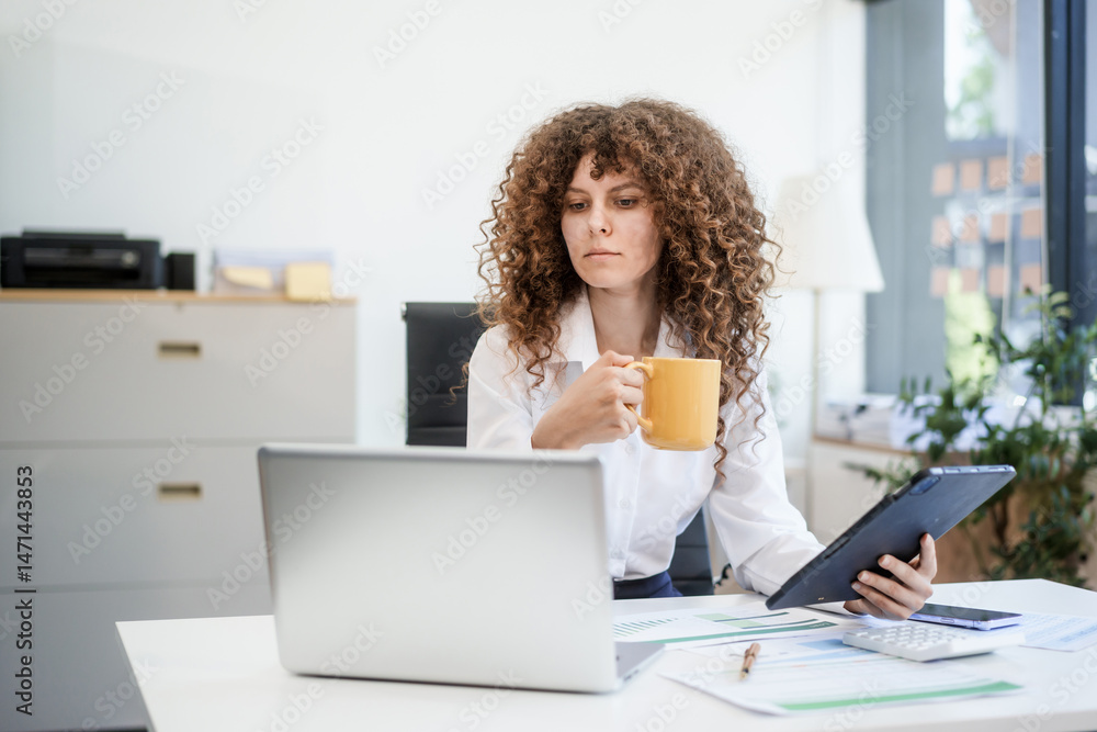 Fototapeta premium Confident Russian consultant sits at modern desk, analyzing market data on laptop. reports and charts, she embodies precision, leadership, and strategic mindset of corporate consulting.