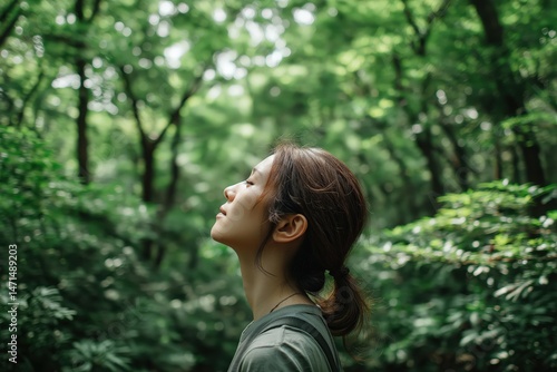 Tranquil woman basking in serene forest ambiance with sunlight filtering through lush green foliage