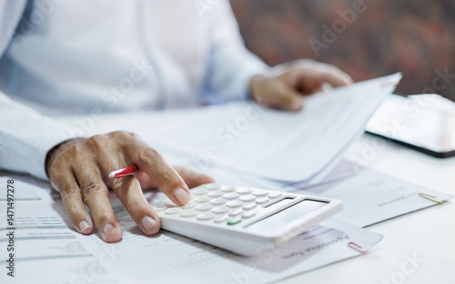 close-up shot, accountants working in office use calculators to calculate business costs, profits and tax