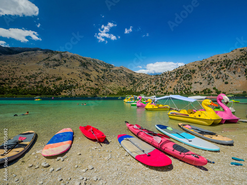 Stand-up paddleboards and kayaks lined up on a freshwater beach (Lake Kournas, Georgioupoli, Crete, Greece)