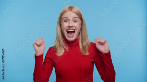 Overjoyed woman celebrating with excitement on blue background