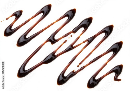 Balsamic glaze drizzled diagonally on a white surface creating a pattern