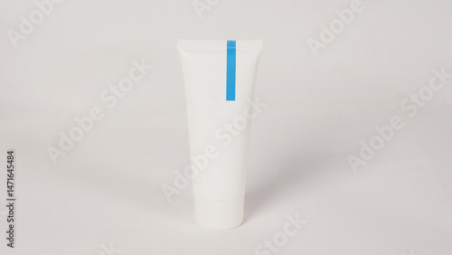 Wallpaper Mural a plain white cosmetic tube with a blue vertical stripe on a white background. Torontodigital.ca