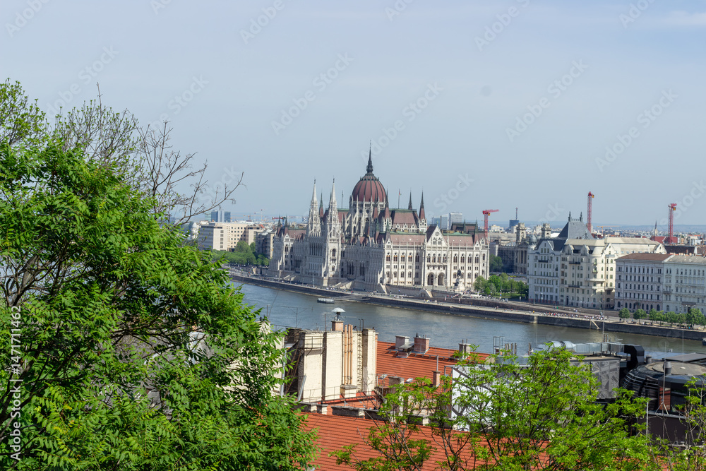 Fototapeta premium Panoramic view of Budapest city with Parliament building, Danube River, bridges and green trees under clear blue sky