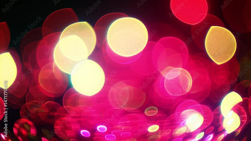 Blurry image of pink and yellow circles. The image has a dreamy, ethereal quality to it, with the pink and yellow circles creating a sense of movement and energy. The colors seem to be swirling